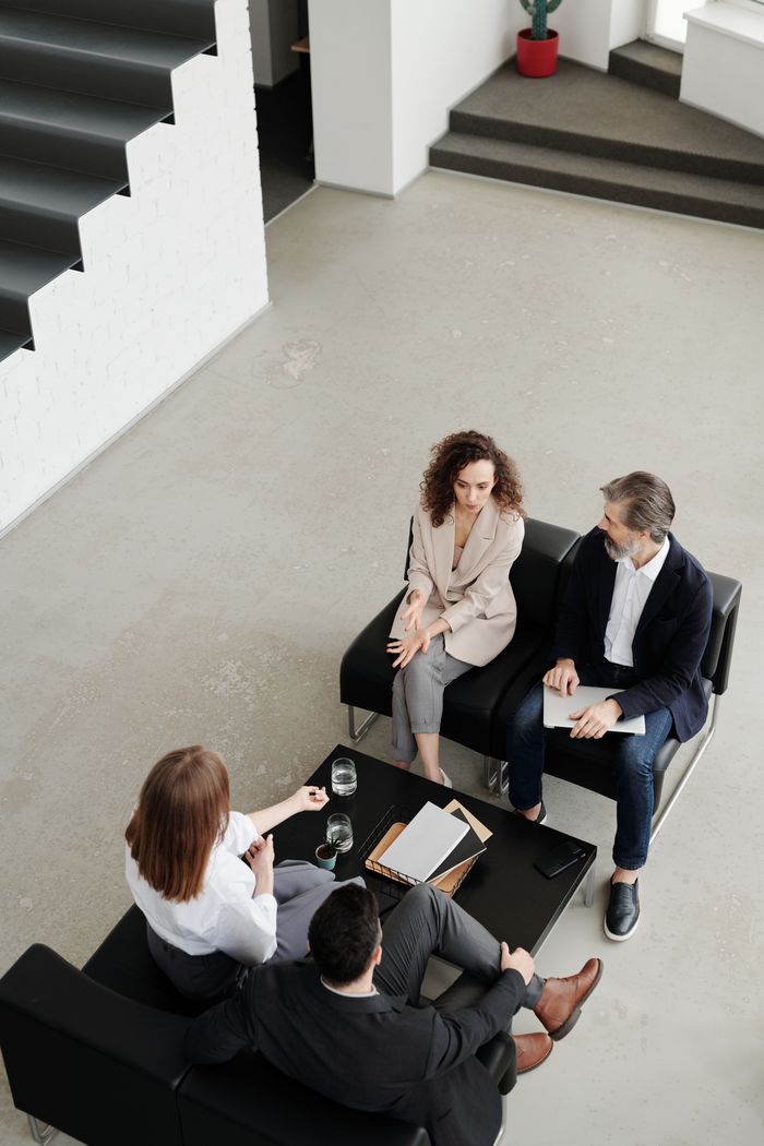 A diverse group of colleagues in a business meeting, discussing strategies around a table.